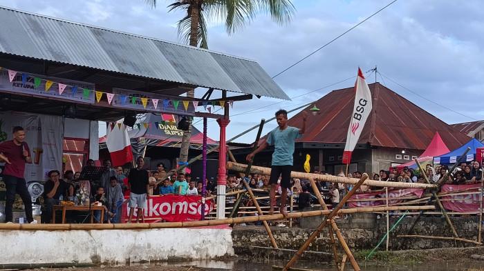 LOMBA -- Seorang warga unjuk kebolehan melewati rintangan