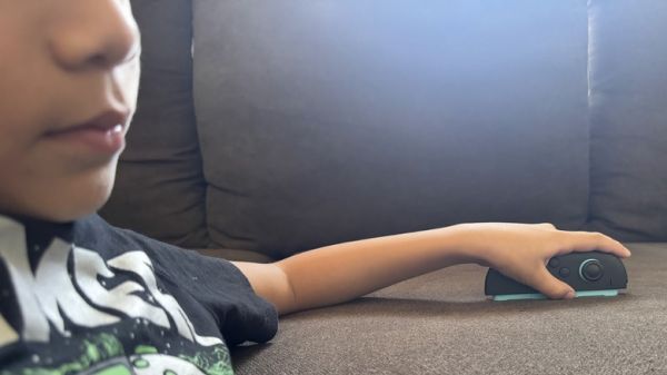 A kid is using a Joy-Con 2 controller in mouse mode