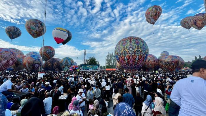 HIASI LANGIT WONOSOBO - Puluhan balon udara berwarna-warni menghiasi langit saat puncak Festival Mudik Balon Udara di Alun-alun Wonosobo, Minggu (29/3/2026). Sebanyak 45 balon diterbangkan secara ditambatkan, disaksikan ribuan warga yang telah memadati lokasi sejak dini hari.