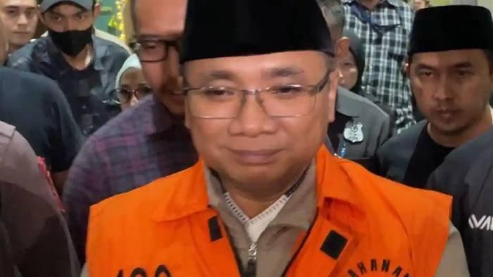 TAHANAN RUMAH - Eks Menteri Agama, Yaqut Cholil Qoumas atau Gus Yaqut melemparkan senyum tipis saat mengenakan rompi tahanan berwarna oranye di Gedung Merah Putih KPK, Jakarta, Kamis (12/3/2026). Gus Yaqut jadi tahanan rumah merupakan sejarah baru di KPK. Menuai reaksi dari berbagai pihak.