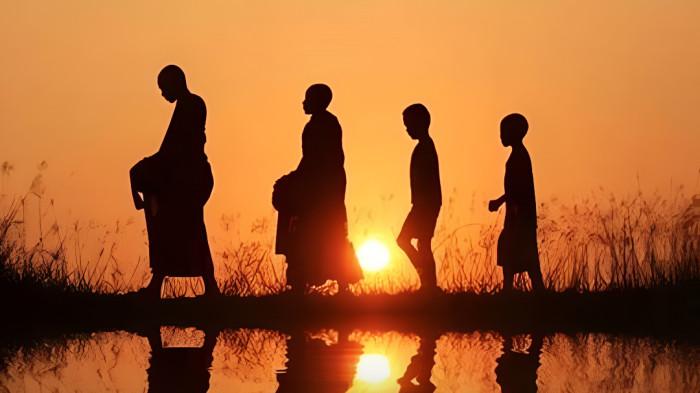 KETENANGAN- Sejumlah bhiksu berjalan di tengah ketenangan alam saat matahari mulai terbenam.