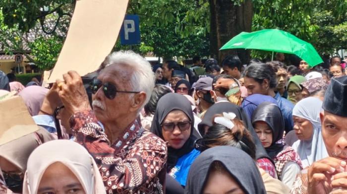 Ribuan warga mengular mengantre di Kompleks Kepatihan Pemda DIY, Senin (30/3/2026), untuk bersilaturahmi dan bersalaman dengan Gubernur DIY Sri Sultan Hamengku Buwono X dalam peringatan Hari Jadi ke-271 DIY. Dalam foto ini, terlihat warga berdesakan dan menggunakan berbagai pelindung panas seadanya, termasuk kardus, payung, tas
