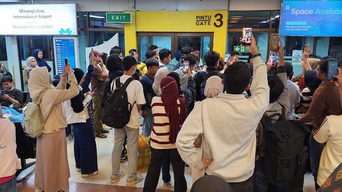KETERLAMBATAN PENERBANGAN - Penumpang berkumpul di depan Pintu Gate 3 Bandara Internasional Minangkabau, Padang Pariaman, Minggu (29/3/2026), menyusul keterlambatan penerbangan IU 905 rute Padang–Jakarta. Penerbangan tersebut sempat mengalami penundaan akibat kendala operasional kru sebelum akhirnya diberangkatkan keesokan harinya.