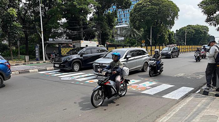 ZEBRA CROSS UNIK - Zebra cross di kawasan Tebet, Jakarta Selatan, mendadak mencuri perhatian publik. Bukan tanpa alasan, marka penyeberangan di Jalan Dr. Soepomo arah Pancoran tampil berbeda setelah digambar ulang oleh warga dengan sentuhan warna-warni dan ilustrasi unik, Selasa (31/3/2026)