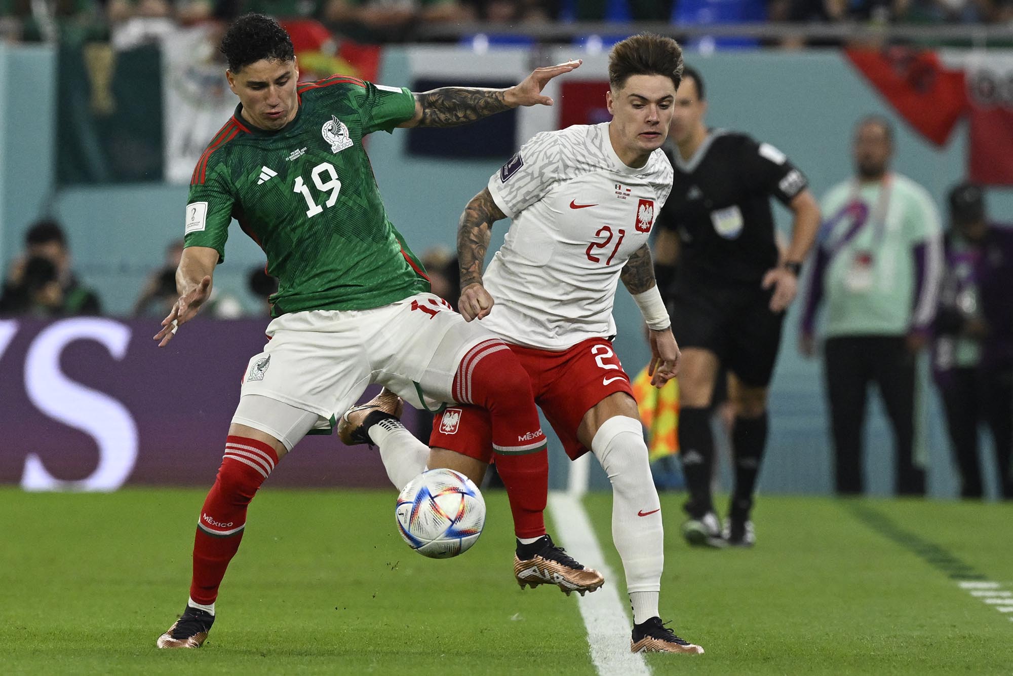 Bek Meksiko Jorge Sanchez (Kiri) berebut bola dengan bek Polandia Nicola Zalewski selama pertandingan sepak bola Grup C Piala Dunia Qatar 2022 antara Meksiko dan Polandia di Stadion 974 di Doha. Selasa (22 November 2022). (Alfredo ETRELLA / AFP) (Foto arsip)