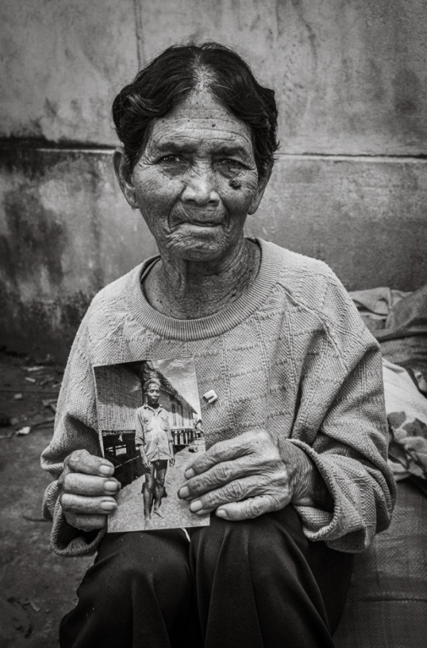 Mrs. Ro Lan Lat next to a photo taken 30 years ago of her late husband.