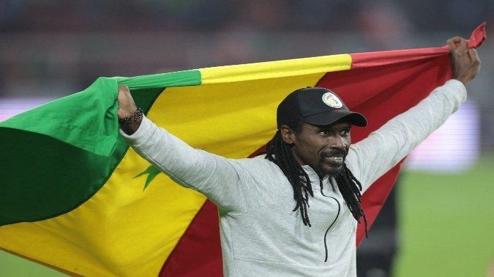 Pelatih Timnas Senegal, Aliou Cisse mengibarkan bendera Senegal saat ia merayakan kemenangan di Piala Afrika 2021 antara Senegal dan Mesir di Stade d'Olembe pada 6 Februari 2022.