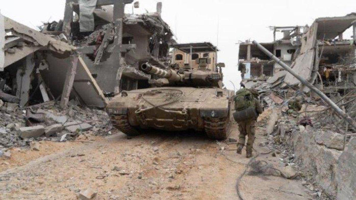 SATUKAN TIGA UNIT - Tentara Israel (IDF) dari satuan infanteri, menyatukan tiga unit tempur didukung peralatan tempur seperti Tank Merkava, untuk merangsek ke dalam Khan Yunis, Gaza Selatan, Kamis (27/12/2023). Brigade AL Qassam dan Brigade Al Quds, sayap militer dari organisasi Hamas dan PIJ, memberikan kejutan dahsyat. Seorang remaja Israel bernama Tal Mitnick (18) dipenjara lantaran menolak perang melawan Hamas, di Gaza, Palestina.