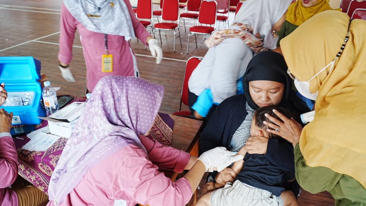 VAKSIN DI KLATEN - Bidan Desa Kraguman Wahyu Waluyanti menyuntikkan vaksin campak kepada balita di Balai Desa Kraguman, Kecamatan Jogonalan, Klaten, sementara orang tua menunggu giliran dalam program ORI Campak di Klaten, pada Selasa (31/3/2026).