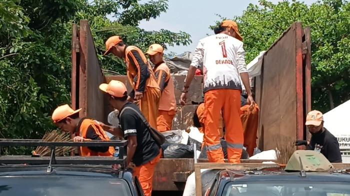 BONGKAR MUAT SAMPAH - Petugas saat melakukan proses bongkar muat sampah dari gerobak motor ke armada truk Dinas Lingkungan Hidup DKI Jakarta, Pasar Rebo, Jakarta Timur, Kamis (2/4/2026). TRIBUNJAKARTA.COM/BIMA PUTRA