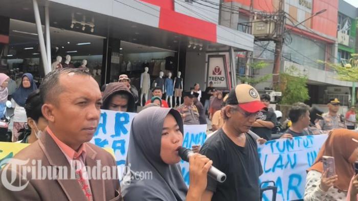 PENGAMEN PADANG MENINGGAL - Kakak sepupu pengamen Karim bernama Ira Rahmi saat berorasi di pertigaan depan Trend Shop, kawasan Pasar Raya, Kota Padang, Kamis (2/4/2025) siang. Aksi demontrasi ini diikuti oleh pihak keluarga, masyarakat, pedagang hingga rekan pengamen Karim (32).