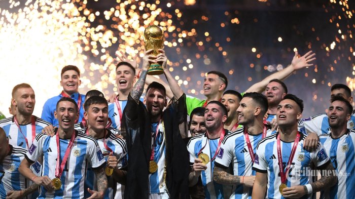 Pemain depan Argentina Lionel Messi mengangkat trofi Piala Dunia selama upacara trofi Piala Dunia Qatar 2022 setelah pertandingan final sepak bola antara Argentina dan Prancis di Stadion Lusail di Lusail, utara Doha. Minggu (18 Desember 2022). Argentina menang dalam adu penalti dengan Prancis. (FRANCK FIFE / AFP)