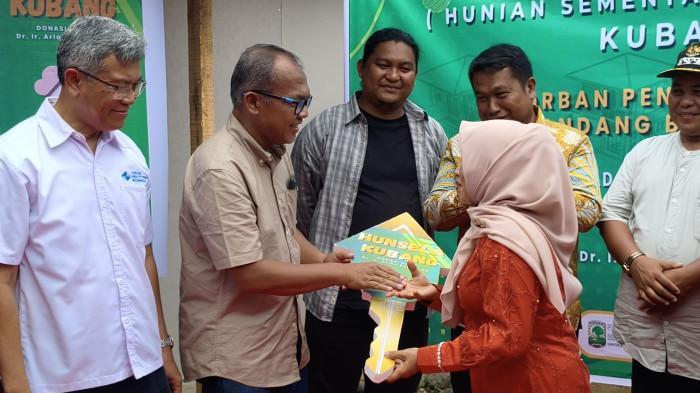 PERESMIAN HUNSELA KUBANG - Penyerahan kunci dua unit hunsela kepada penyintas bencana dari Kelurahan Lambung Bukit, kawasan Batu Busuak oleh inisiator di Kubang, Kelurahan Limau Manis, Kota Padang, Sabtu (4/4/2026). (Tribunpadang.com/Muhammad Iqbal).