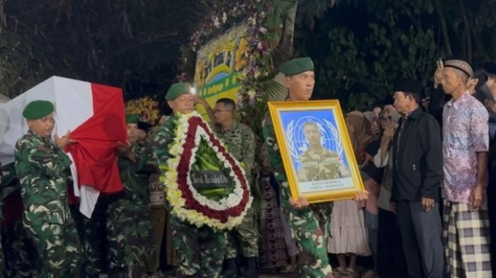 TIBA DI RUMAH DUKA - Prajurit TNI membawa karangan bunga dan foto dari almarhum Kopral Dua (Kopda) Anumerta Farizal Rhomadhon, prajurit TNI yang gugur dalam misi perdamaian Perserikatan Bangsa-Bangsa (PBB) di Lebanon (UNIFIL), setibanya di rumah duka, Kalurahan Sidorejo, Kapanewon Lendah, Kabupaten Kulon Progo, Daerah Istimewa Yogyakarta, Sabtu (4/4/2026) malam. Iring-iringan mobil jenazah yang membawa peti berbalut bendera Merah Putih memasuki halaman rumah duka sekitar pukul 22.42 WIB. Sebelumnya, jenazah telah menjalani prosesi penghormatan kenegaraan di Jakarta yang dipimpin langsung oleh Presiden Prabowo Subianto.