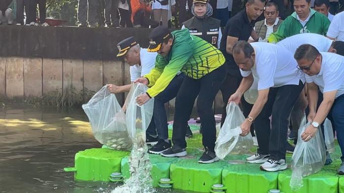 KERJA BAKTI - Wali Kota Jakarta Selatan M Anwar melepas ikan tawes di Waduk Cavalio