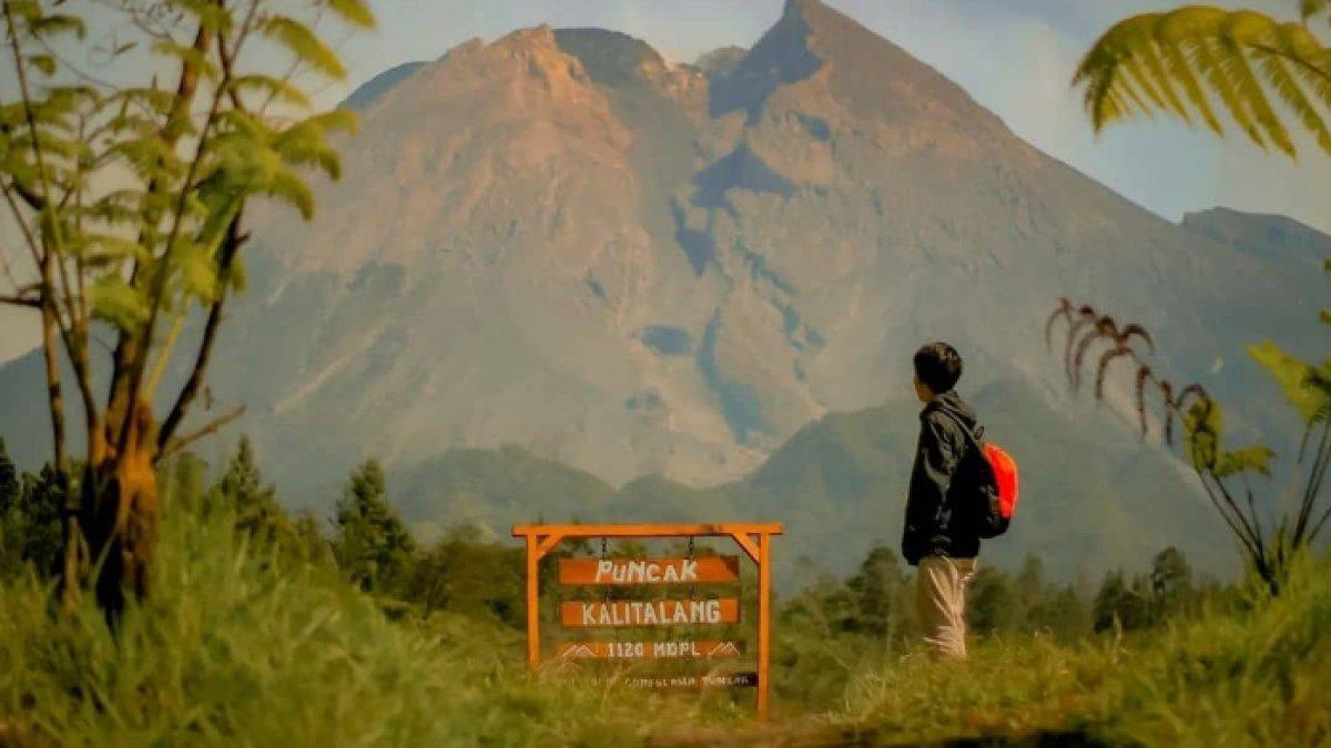 OBYEK WISATA KLATEN: Seorang pendaki yang berdiri di Puncak Kalitalang, dengan latar belakang Gunung Merapi yang megah