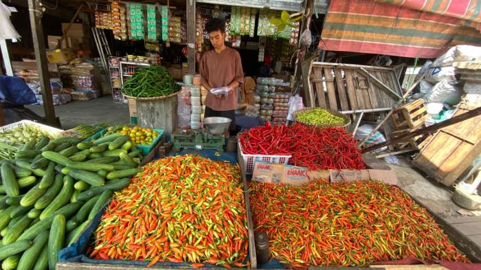 MELAYANI - Pedagang melayani pembeli di lapak cabai Pasar Besar Palangka Raya, Senin (6/4/2026). Dua pekan usai Lebaran, harga cabai masih tinggi dan belum stabil.
