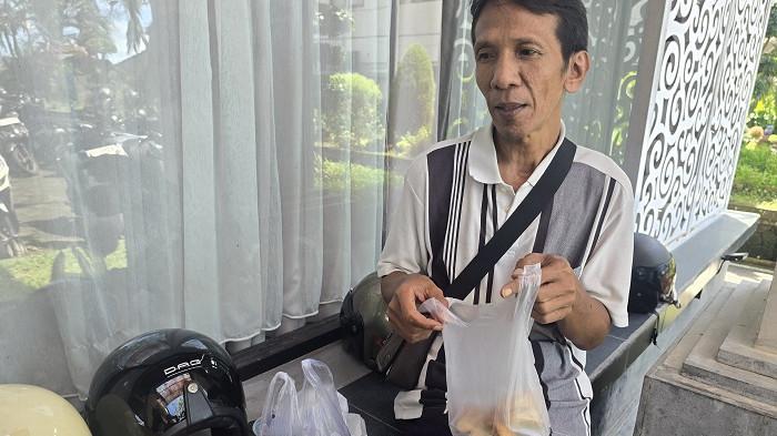 SOSOK - Seorang pedagang di Karangasem menunjukan tas plastik, yang harganya melambung tinggi, Selasa (7/4/2026).
