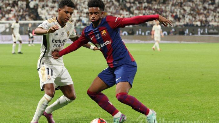 BARCELONA MENANG TELAK - Pemain depan Real Madrid asal Brazil Rodrygo dan bek Barcelona asal Spanyol Alejandro Balde berebut bola pada pertandingan sepak bola final Piala Super Spanyol antara Real Madrid dan Barcelona di Stadion Al-Awwal Park di Riyadh, pada 14 Januari 2024. (Photo by Giuseppe CACACE / AFP)