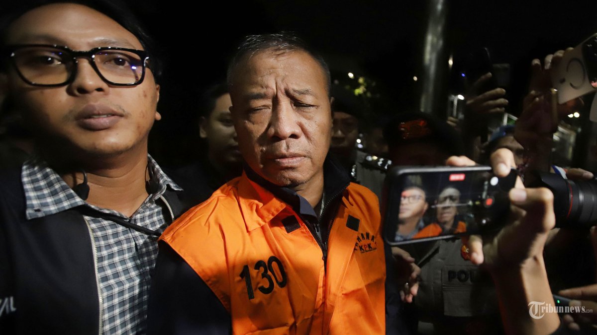BUPATI TULUNGAGUNG TERSANGKA - Bupati Tulungagung Gatut Sunu Wibowo mengenakan rompi orange  saat berjalan meninggalkan gedung Komisi Pemberantasan  Korupsi (KPK) di Jakarta, Minggu (12/4/2026) dini hari. KPK menetapkan Bupati Tulungagung Gatut Sunu Wibowo sebagai tersangka kasus pemerasan para Organisasi Perangkat Daerah di Pemerintah Kabupaten Tulungagung. Selain Gatut, KPK juga menetapkan Dwi Yoga Ambal (YOG) selaku ADC atau ajudan bupati sebagai tersangka. GSW diduga meminta sejumlah uang kepada para KepalaOrganisasi Perangkat Daerah (OPD) dan pejabat lainnya, baik secara langsung maupun melalui YOG dengan total permintaan sekitar Rp5 miliar. Selain itu, GSW diduga melakukan pengaturan vendor pengadaan alat kesehatan di RSUD agar dimenangkan. Ia juga diduga meminta agar rekanannya menjadi pemenang dalam penyediaan jasa cleaning service dan security. Tribunnews/Jeprima