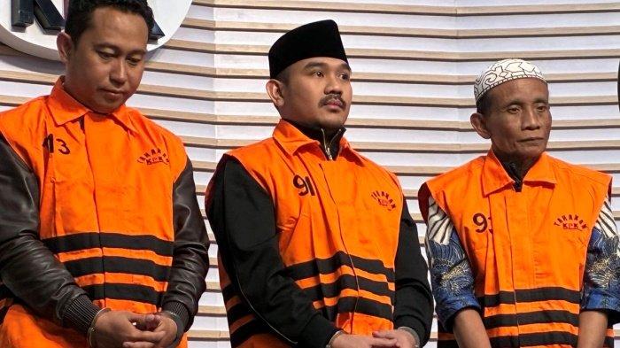 KEPALA DAERAH KORUPSI - Komisi Pemberantasan Korupsi (KPK) menetapkan Bupati Bekasi Ade Kuswara Kunang (tengah), HM Kunang (tiga dari kiri) selaku ayah Bupati, dan Sarjan (kiri) selaku pihak swasta, sebagai tersangka terkait kasus dugaan suap ijon proyek di Kabupaten Bekasi, Sabtu (20/12/2025). (Kompas.com/Haryanti Puspa Sari)