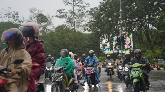 CUACA KALBAR BESOK - Pengendara motor dan mobil melintasi Tugu Digulis Untan Jalan Jendral Ahmad Yani, Kota Pontianak, Provinsi Kalimantan Barat saat hujan deras pada Rabu 4 Februari 2026 pagi. Berikut prakiraan cuaca Kalbar besok, 14 April 2026..