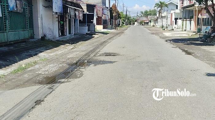 JALAN BERLUBANG - Kondisi jalan di Dusun Songgorunggi, Desa Dagen, Kecamatan Jaten, Kabupaten Karanganyar, Minggu (13/4/2026). Lubang-lubang besar menganga di sepanjang jalan bahkan mencapai kedalaman sekitar 40 sentimeter dan memicu kecelakaan bagi pengguna jalan. Perbaikan jalan ini baru dilakukan setelah Karang Taruna setempat turun tangan menguruk lubang, yang kemudian disusul perbaikan tambal sulam oleh Pemerintah Kabupaten Karanganyar.
