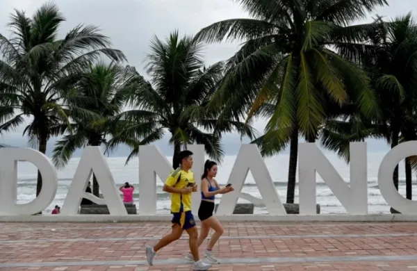 Two tourists are jogging in front of a beach in Da Nang. Photo: AFP