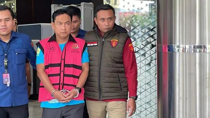 KETUA OMBUDSMAN DITANGKAP - Ketua Ombudsman RI, Hery Susanto ditangkap Kejaksaan Agung (Kejagung). Ia terlihat keluar dengan tangan diborgol dan memakan rompi tahanan saat masuk ke dalam mobil tahanan di Kantor Kejaksaan Agung, Jakarta, Kamis (16/4/2026). (Tribunnews.com/Abdi Ryanda Shakti)