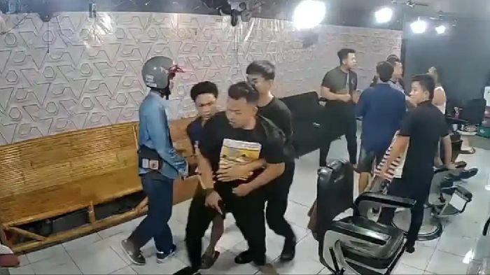 TODONGKAN SENPI - Jepretan layar empat orang diduga oknum Polisi menodongkan senjata api kepada pekerja pangkas rambut, di pangkas kjr 99, di Jalan Mustafa, Kelurahan Glugur Darat I, Kecamatan Medan Timur, Kota Medan, Sumatera Utara, pada Senin (6/4/2026). (TRIBUN MEDAN/ISTIMEWA)