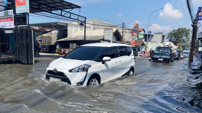 BANJIR DERWATI - Sejumlah pengendara menerjang banjir di Jalan utama Derwati, Kota Bandung, Selasa (14/4/2026). Tribun Jabar/Hilman Kamaludin.