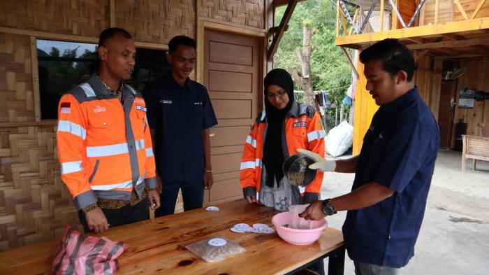 MENGEMAS PAKAN TERNAK - Tim Community Relations Solusi Bangun Andalas dan Basagmil sedang mengemas pakan ternak dengan branding 