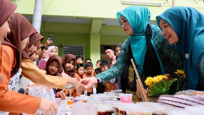 MEMBORONG JAJANAN – Ketua TP PKK Aceh, Marlina Muzakir alias Kak Na, memborong jajanan sehat milik siswa MIN Model Banda Aceh, pada Market Day sekolah tersebut, Sabtu (18/4/2026).