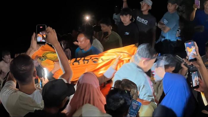 BOCAH HANYUT -- Tim SAR dan warga mengevakuasi jenazah bocah yang ditemukan meninggal terseret air sungai Bolango.