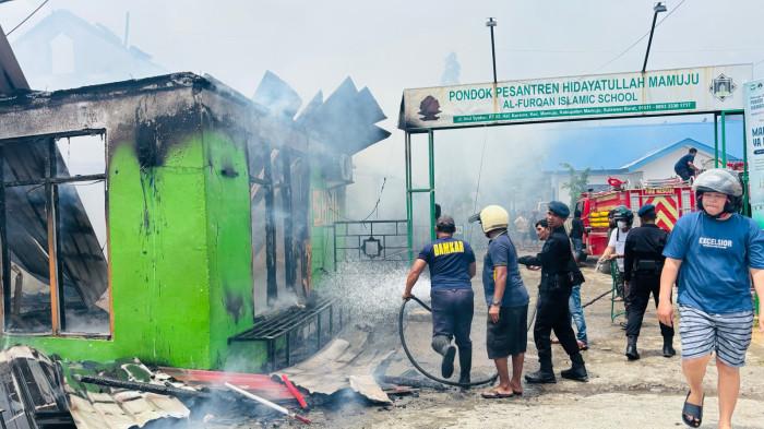 KEBAKARAN - Petugas yang sedang memadamkan api yang melalap gedung Pondok pesantren Hidayatullah Mamuju, Minggu (19/4/2026).