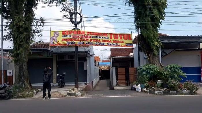 SPANDUK UNTUK TUYUL - Pemasangan spanduk tuyul dilarang beraksi di lingkungan Kampung Kebon Kembang, RT 05/05, Cipedes, Kota Tasikmalaya gegara uang hilang misterius, Minggu (19/4/2026).