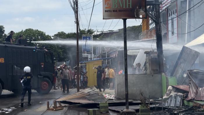 BANTU PADAMKAN API - Personel Brimob Polda Sulbar saat membantu memadamkan api di Pondok Pesantren Hidayatullah Mamuju, Minggu (19/4/2026).