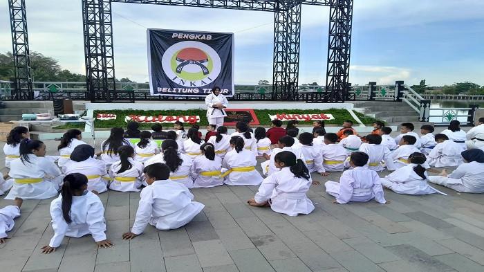 FOTO BERSAMA -- Ketua INKAI Kabupaten Belitung Timur, Fitri Zakiah berfoto bersama para karateka muda, pelatih (senpai), dan orang tua saat peringatan HUT ke-55 INKAI di tepi Situ Kulong Minyak, Manggar, Minggu (19/4/2026). Selain memperkuat soliditas organisasi yang telah berdiri dua dekade di Belitung Timur, momentum ini juga digunakan untuk memotivasi para atlet agar terus berprestasi hingga ke kancah internasional.