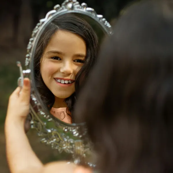 young girl happy with what she sees in the mirror