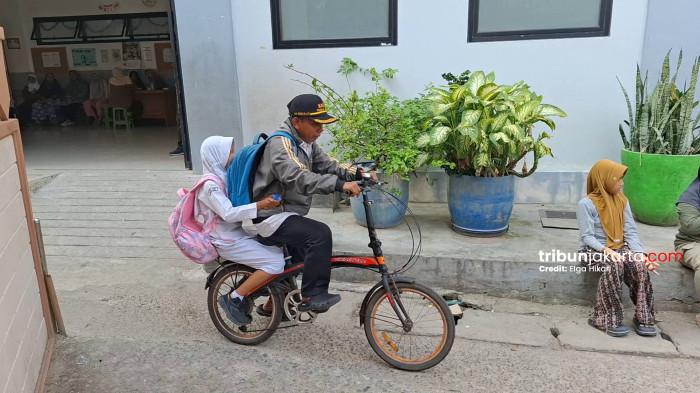GURU HONORER - Abdul Azis (45) guru honorer di Jakarta Utara yang menggunakan sepeda bersama sang anak untuk menuju ke sekolah tempatnya mengajar. TRIBUNJAKARTA.COM/ELGA PUTRA