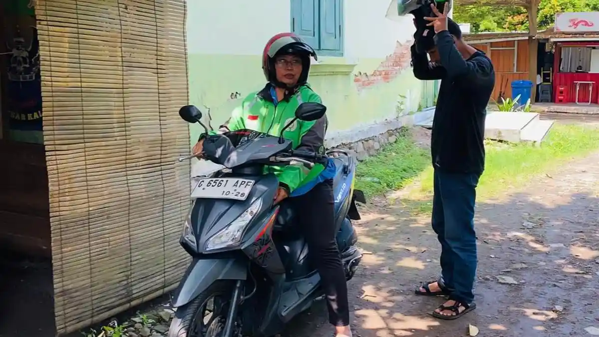 PENGEMUDI OJOL PEREMPUAN - Sosok perempuan inspiratif dari Slawi Kulon, Kabupaten Tegal, bernama Agnes Ervina sedang menjalankan profesi sebagai ojek online yakni menjemput customer di Kelurahan Pakembaran Slawi, Kabupaten Tegal, Senin (20/4/2026). Agnes Ervina merupakan sosok perempuan hebat yang menjadi single mom sejak tahun 2014 karena suaminya meninggal dunia, berkat perjuangan dan keteguhannya sang anak berhasil menjadi prajurit TNI berpangkat Serda. 