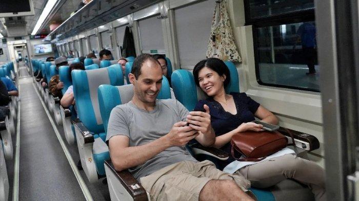 Penumpang menikmati perjalanan kereta api.