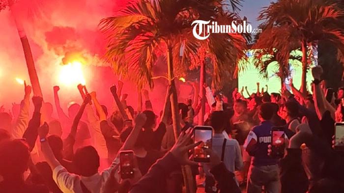 NYALAKAN FLARE - Suasana nonton bareng (nobar) Persis Solo vs Bhayangkara Lampung FC di The Apic, Klodran, Karanganyar, Rabu (22/4/2026). Fans Persis Solo menyalakan flare saat merayakan kemenangan Laskar Sambernyawa. Diketahui, laga di Stadion Manahan Solo tersebut tak bisa disaksikan suporter secara langsung lantaran Persis masih menjalani sanksi larangan dengan penonton.