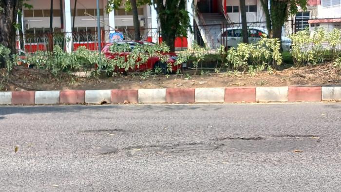 JALAN RUSAK - Lubang di Jalan Ahmad Yani, Sario, Manado, Sulawesi Utara, Kamis (