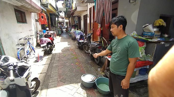 KORBAN PENUSUKAN - Saat Iwan, adik sepupu korban MJ menunjukkan lokasi korban terkapar di tengah gang permukiman padat kawasan Jalan Pragoto II, Simolawang, Simokerto, Surabaya, pada Kamis (23/4/2026) pagi.