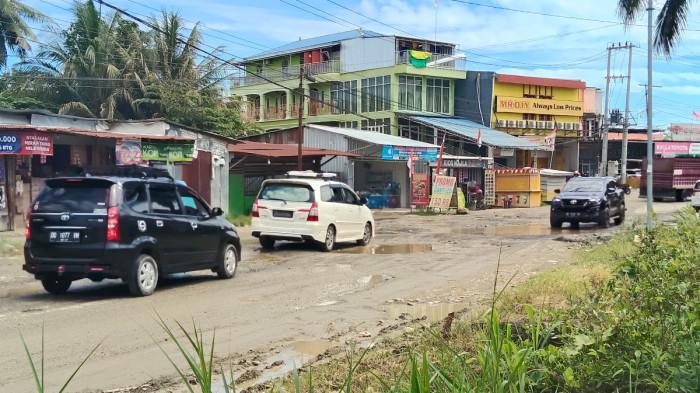 JALAN RUSAK - Pengendara mengeluhkan kondisi jalan rusak di ruas Trans Sulawesi, tepatnya di Desa Topoyo, Kecamatan Topoyo, Kabupaten Mamuju Tengah, Sulawesi Barat. Jalan berlubang dan tergenang air itu berada di depan Cafe Betutu Mateng dan Barber Shop Arkana.