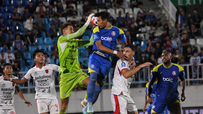 Pesepakbola Arema FC,  Hansamu Yama (atas) berebut bola dengam kiper Bali United, Mike Hauptmeijer (bawah) dalam laga lanjutan Super League 2025-2026 di Stadion Kanjuruhan, Kabupaten Malang, Jawa Timur, Jumat (6/3/2026). Arema FC kalah dari Bali United dengan skor 3-4. SURYA/PURWANTO