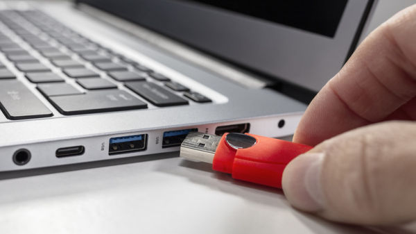 person plugging USB to laptop