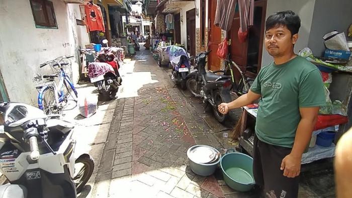KASUS PENUSUKAN - Iwan (34), adik sepupu korban MJ, saat menunjukkan lokasi korban terkapar di tengah gang permukiman padat penduduk kawasan Jalan Pragoto II, Simokerto, Surabaya, Jawa Timur pada Kamis (23/4/2026) pagi.