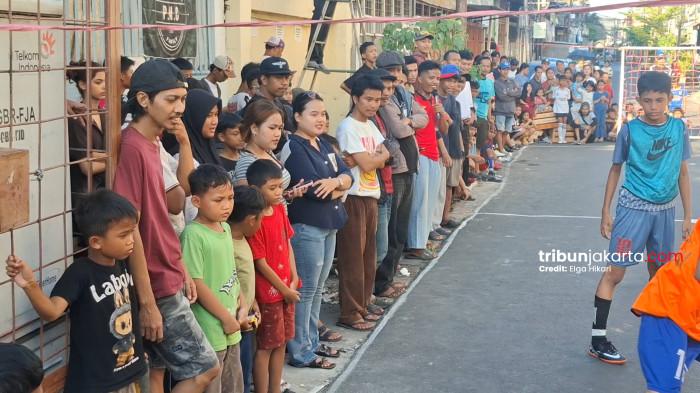 ANTUSIAS NONTON BOLA JALANAN - Warga antusias menyaksikan Liga Akamsi yang digelar di  Gang Kiara 5 RW 05, Jembatan Lima, Tambora, Jakarta Barat atau di dekat Pasar Buah Angke pada Minggu (26/4/2026) sore.TRIBUNJAKARTA.COM/ELGA PUTRA